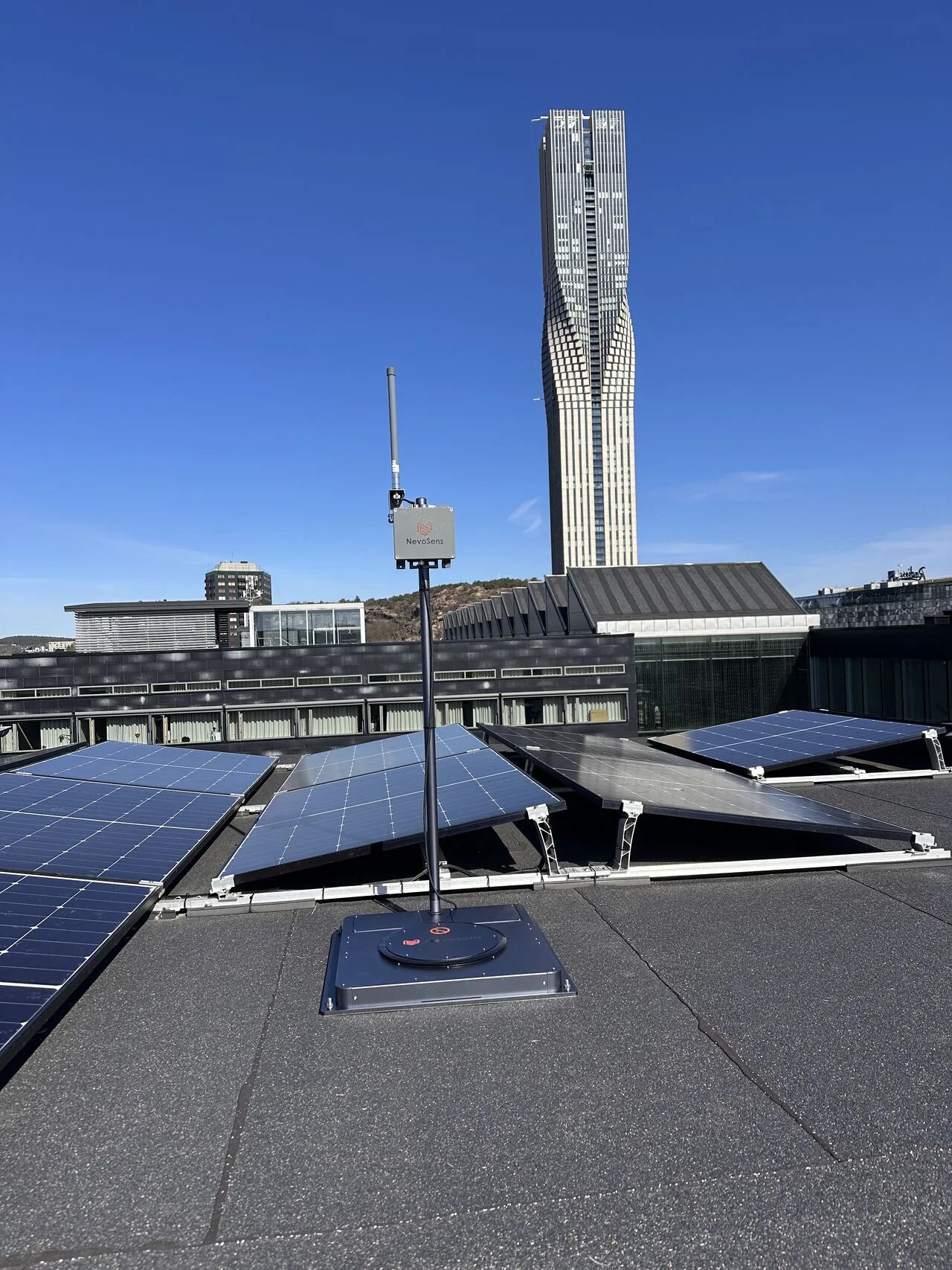 NevoSens snösensor och gateway monterad på tak vid solcellsanläggning på Lindholmen i Göteborg, med Karlatornet i bakgrunden